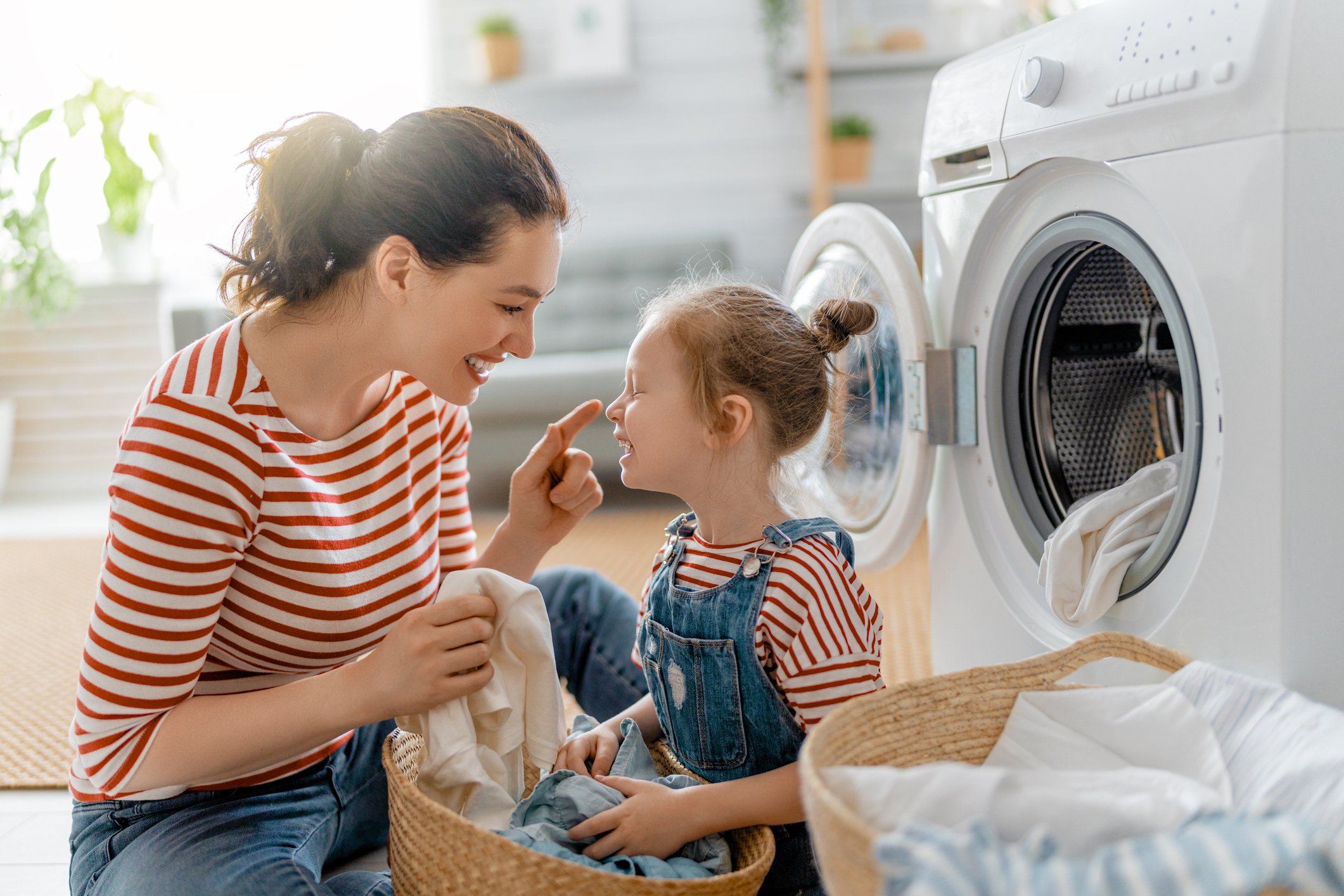  mother and daughter folding clothes from dryer