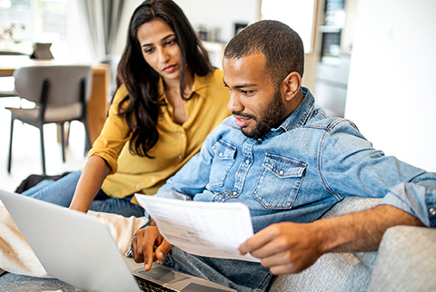 Couple looking at bill on laptop