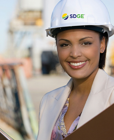 Smiling woman wearing hard hat with the SDG&E logo on it